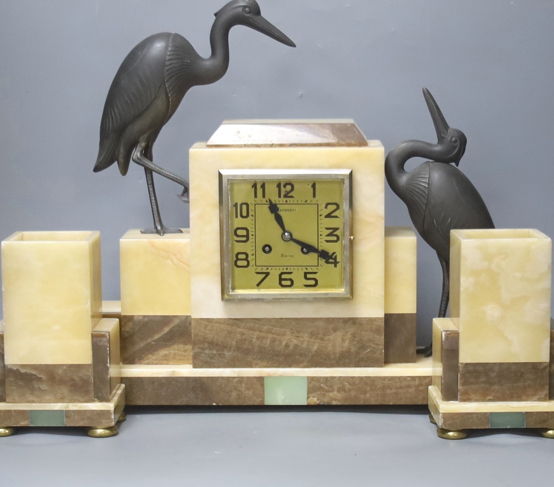 An Art Deco marble clock garniture clock surmounted with two spelter cranes, 42cm